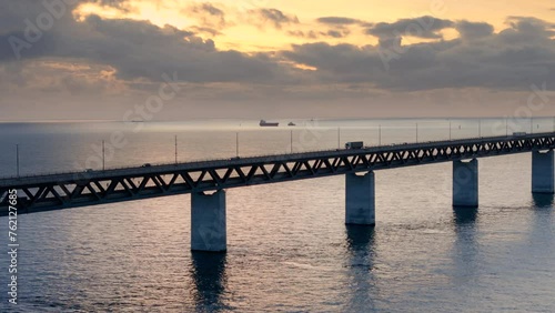 Vivid golden hour aerial dolly view of traffic flow over iconic Oresund bridge photo