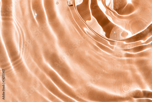 фотографія Textured background of waves on peachy water with solar lightning