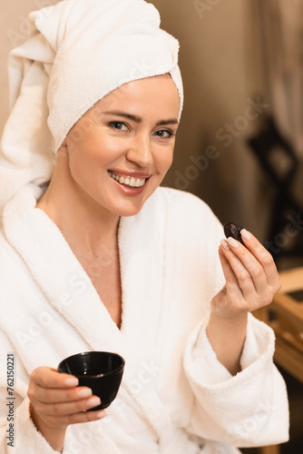 Portrait of beautiful woman in bathrobe drinking herbal tea and enjoying spa services. Spa for woman