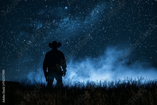 Silhouette of a lonesome cowboy with smoke trail under a starry night western spirit. photo