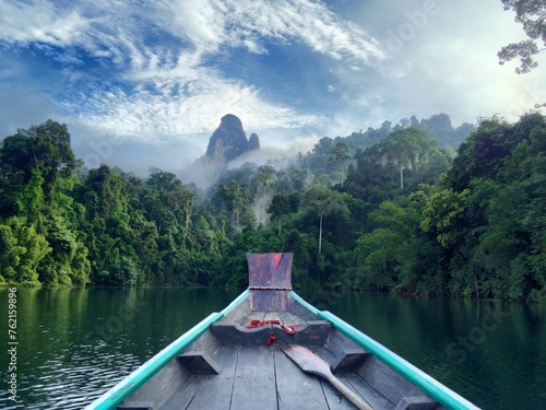 tropical boat on lake with rainforest mountains photo