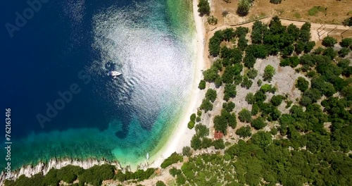 Overhead orbiting drone shot of Foki Beach, a secluded public resort near the village of Fiskardo, located in the island of Kefalonia, Greece. photo