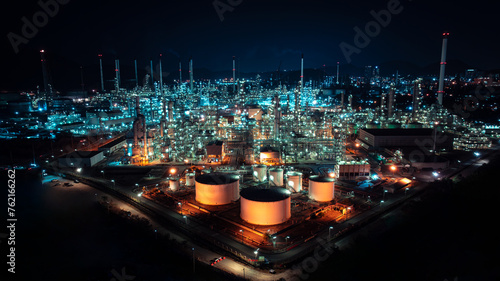 Oil refinery plant industry factory zone, oil and gas petrochemical industrial, oil storage tank and pipeline steel at night scene shot blue sky backgrounds,