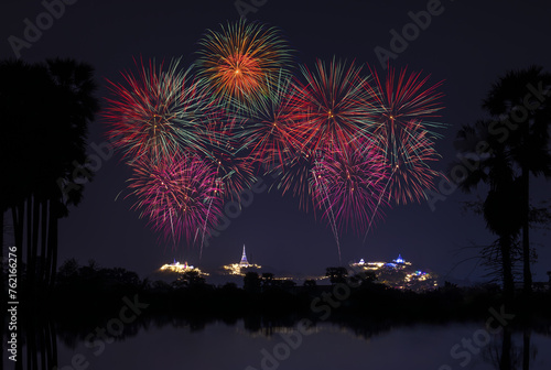 Firework over the mountain in the festival (Phra Nakhon Khiri) and shadow of the sugar palm tree reflection in water front process.