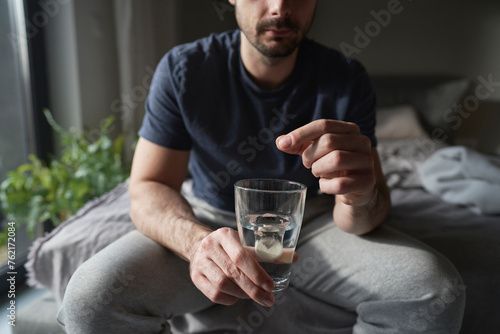 Close up of man putting calcium in the the glass with water