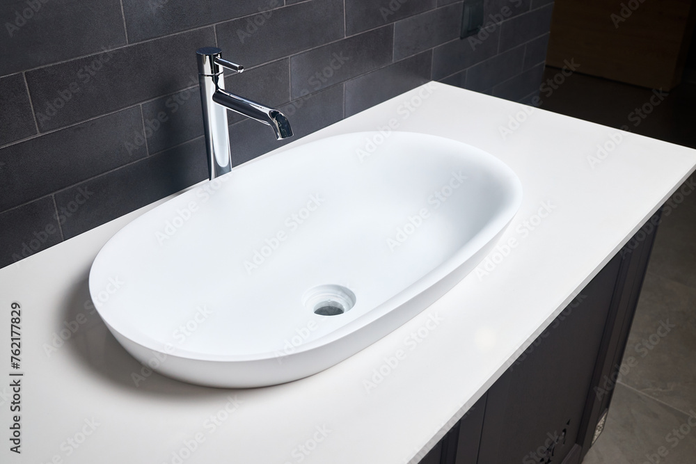 Fototapeta premium Interior of bathroom with washbasin and faucet. Bathroom interior sink with white stoneware countertop modern flat minimalistic design.