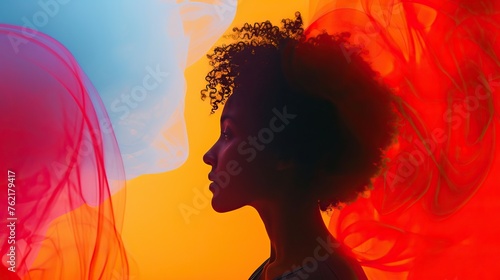 Silhouette of a woman with curly hair against a vibrant orange and red backdrop, evoking warmth and creativity.