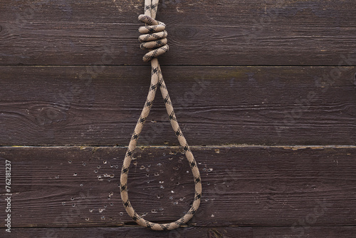 Fototapeta Rope with noose for suicide on wooden background