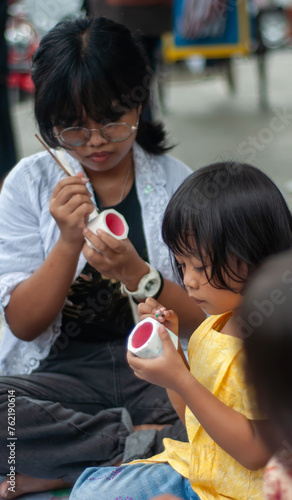 girl is coloring ceramics