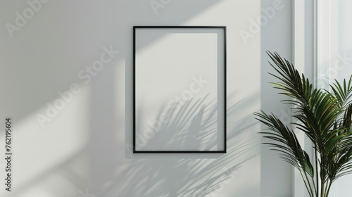 mockup of vertical, blank white canvas with slim,wooden black frame on white wall