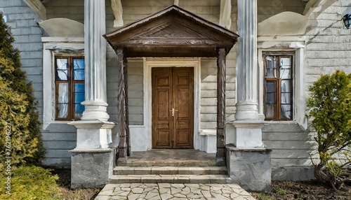 entrance to the old house  Main entrance door in house. Wooden front door with gabled porch and landing. Exterior of georgian style home cottage with columns
