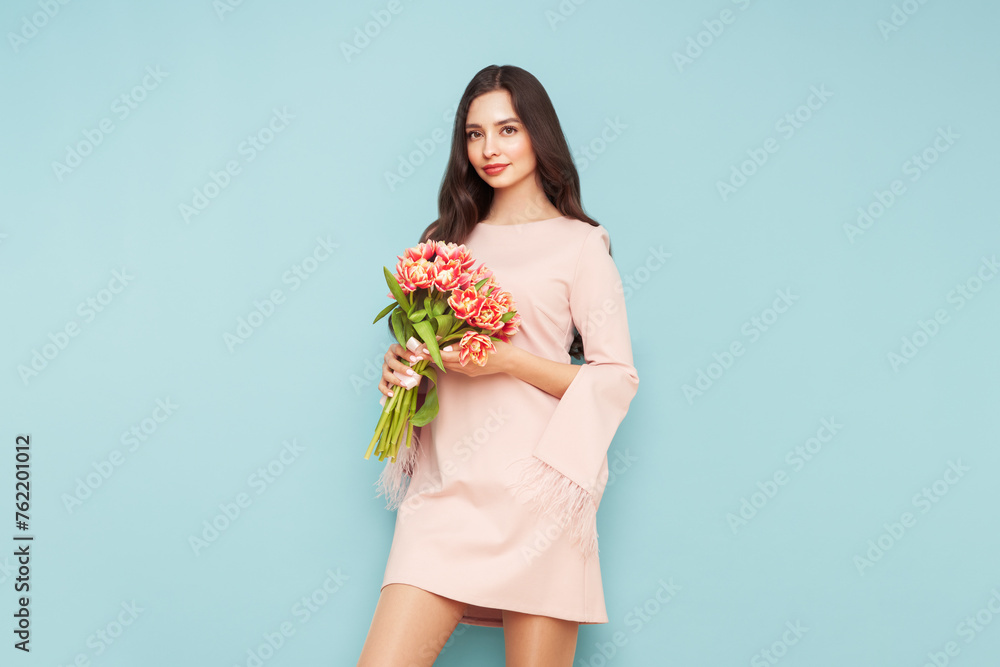 Happy beauty woman with pink tulip bouquet on light blue background. 8th of March celebration Happy beauty woman with pink tulip bouquet on light blue background. 8th of March celebration