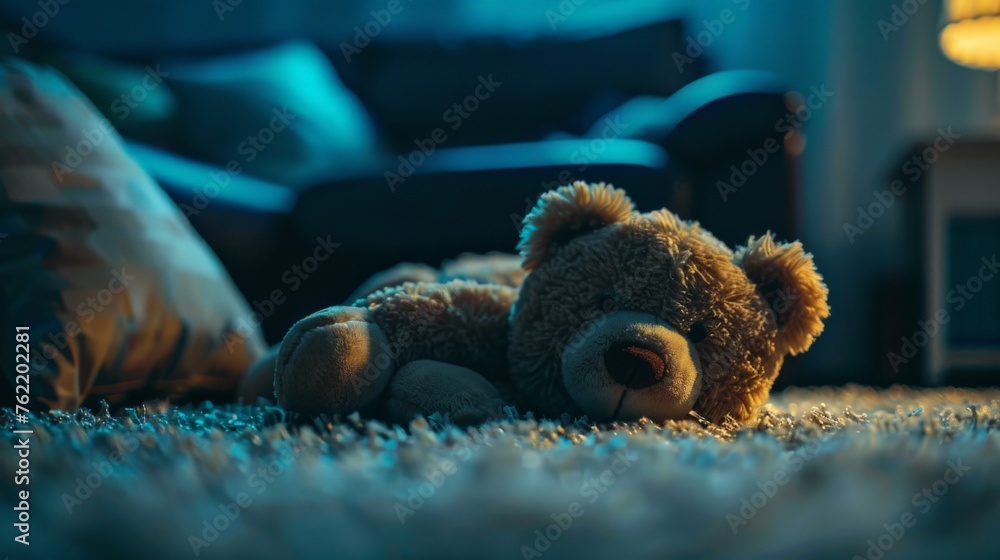 Teddy bear is laying down on carpet in cinematic tone, Dramatic shot of Lonely teddy bear laying down alone in living room at night ,lonely concept, international missing children's day. Teddy bear is laying down on carpet in cinematic tone, Dramatic shot of Lonely teddy bear laying down alone in living room at night ,lonely concept, international missing children's day.
