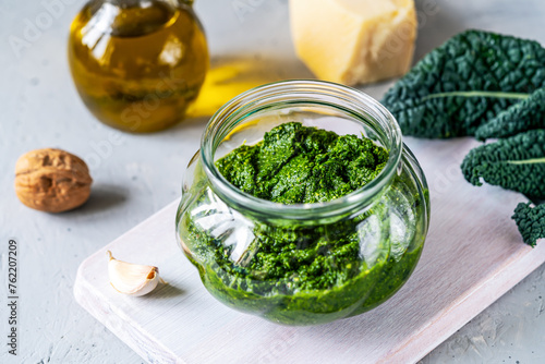 Fresh Homemade Kale Pesto Sauce in Open Jar with Ingredients