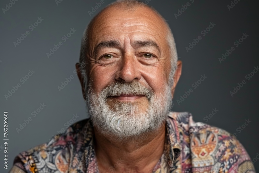 Obraz premium Elderly man smiling at camera. A close-up portrait of an elderly, man with a warm smile, wearing fashionable clothes.