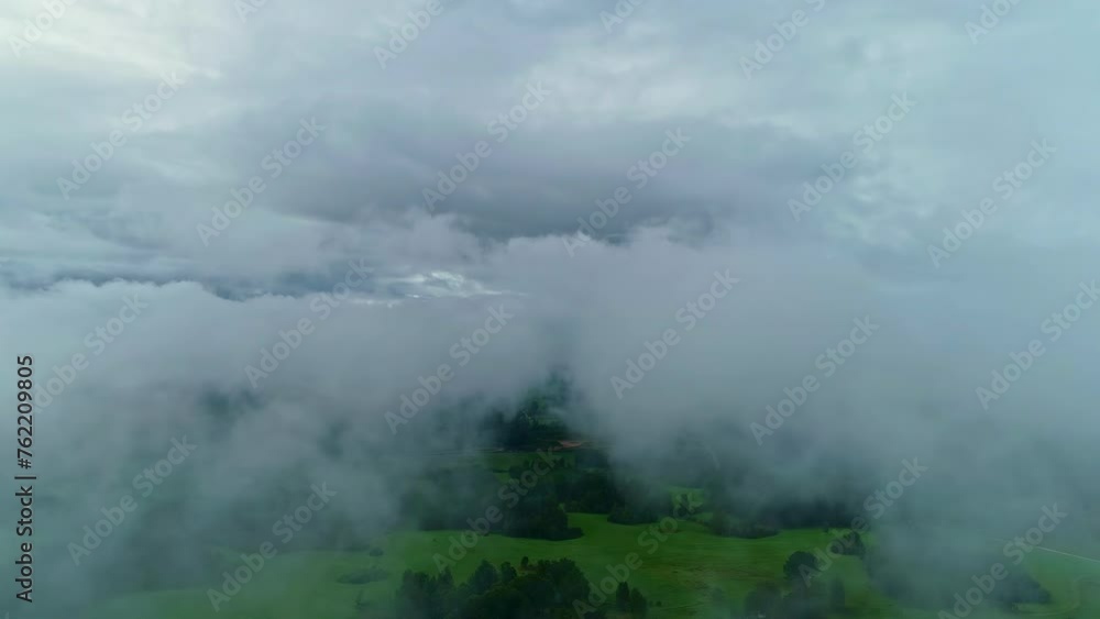 Rural area covered in thick fog, aerial view from above low clouds in the dawn Rural area covered in thick fog, aerial view from above low clouds in the dawn