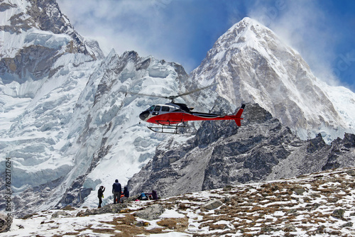 Goup of climbers in the Himalayas, view on peak Pumori. Rescue helicopter in action, Nepal photo