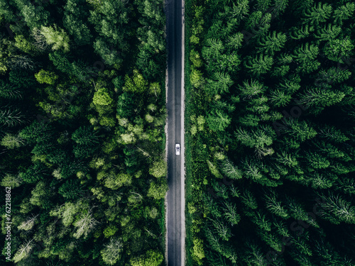 Aerial view green summer forest and asphalt road with car