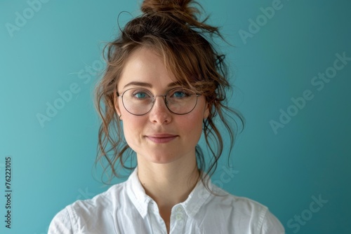 Professional woman in casual attire against a teal background