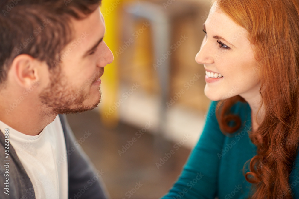 Naklejka premium Couple, smile and romance with eye contact in cafe, support and happiness for peace in relationship. Adult, woman and girl with love for man or partner in coffee shop and joy for marriage with guy