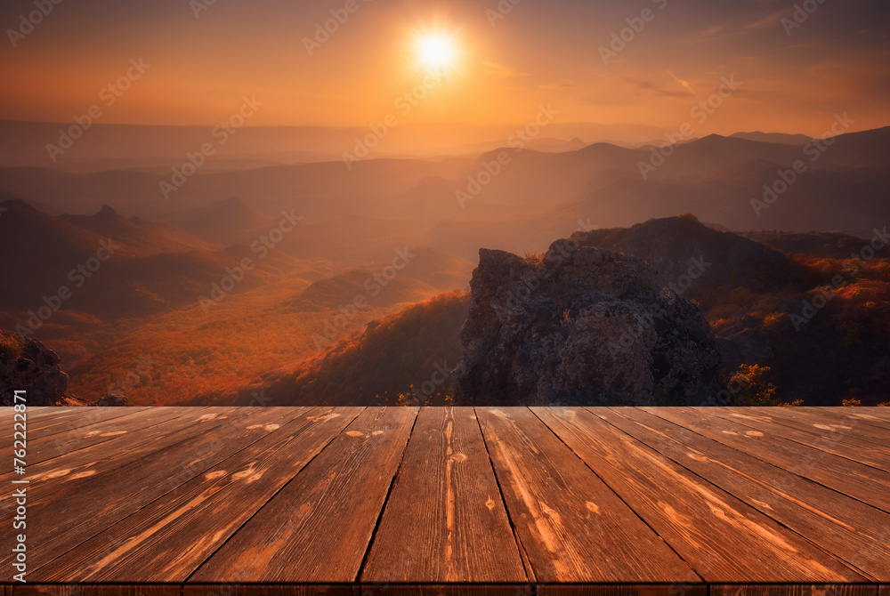 Sunset over mountains and empty wooden table in nature outdoor. Natural template landscape
