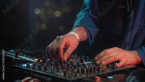 Deejay is mixing music on a musical instrument accessory at art festival, providing entertainment for the audience. The electronic instrument is creating a vibrant concert atmosphere