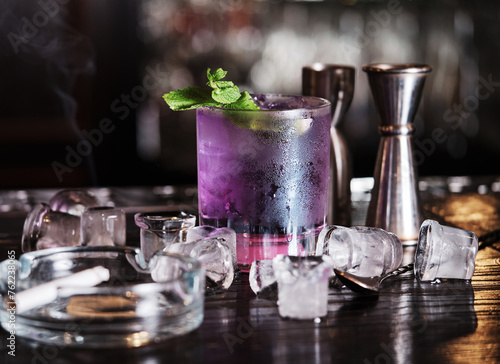 A visually striking image capturing a cocktail with a beautiful gradient of colors, adorned with a fresh mint garnish.
