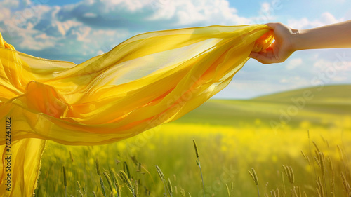 Beautiful young woman with yellow scarf on the wind in the spring photo