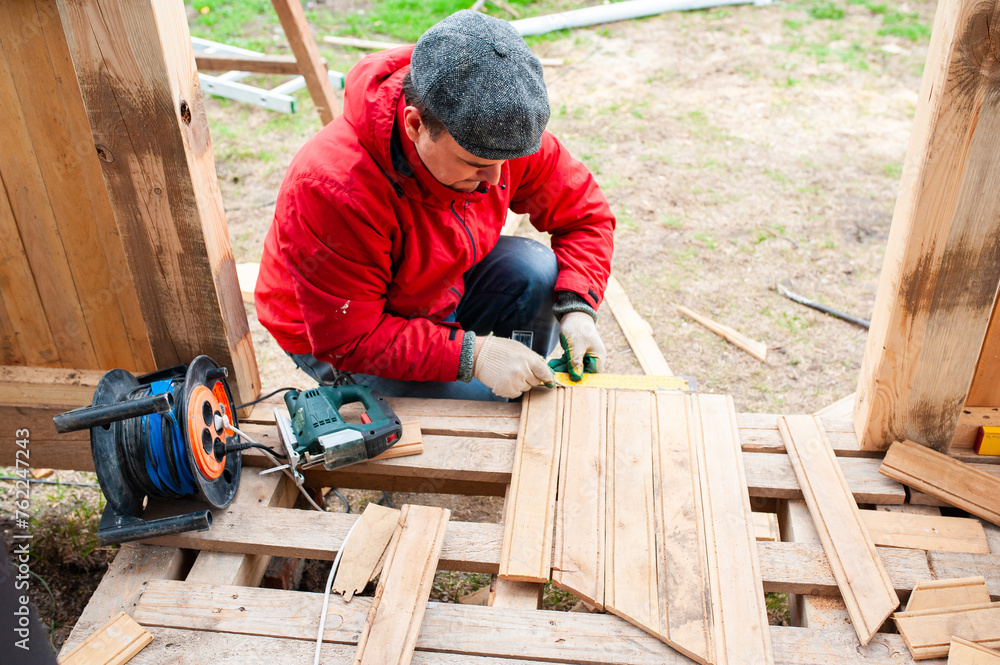 Worker sawing boards for construction