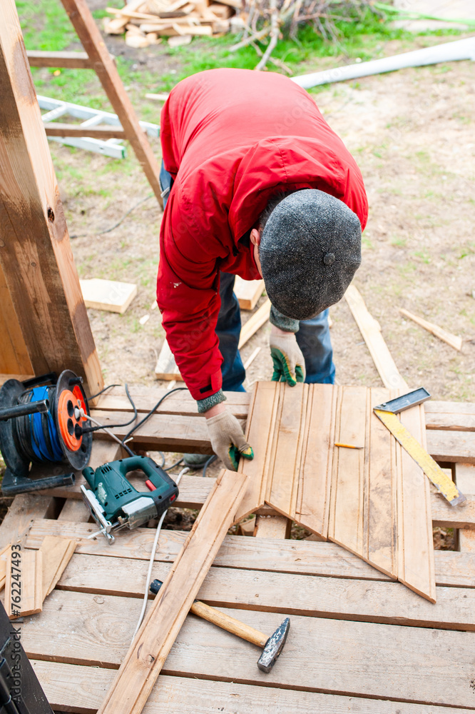 Worker sawing boards for construction