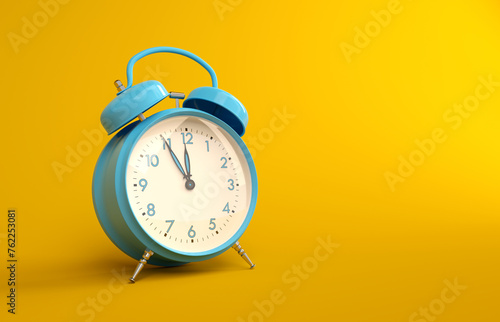 Blue metal vintage alarm clock on yellow background. Analogue alarm clock five to twelve copy space illustration.