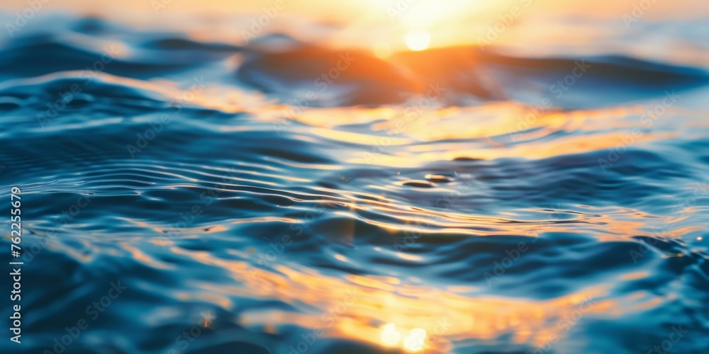 Obraz premium Sunset over calm ocean creating golden reflections on the water surface.