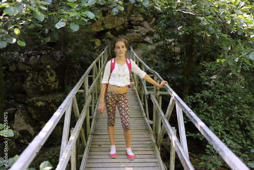young girl stands on bridge over river Agura, Sochi, Krasnodar Territory