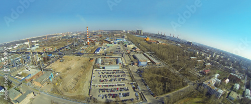 The territory of oil processing plant near the city on sunny spring day, aerial view