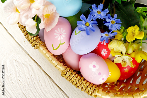 Easter Eggs in the basket with bakery cake fresh baked on white wooden table background