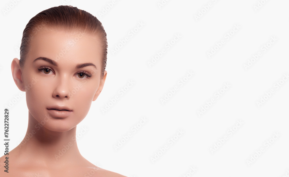 Fototapeta premium Beauty skin. Head and shoulders of blond woman model, touching glowing, hydrated facial skin, apply toner, skin cream or lotion for healthy look, after shower portrait, white background.