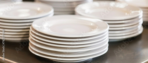 Stack of white plates, immaculately arranged with a shining detergent finish, ready for dinner service.