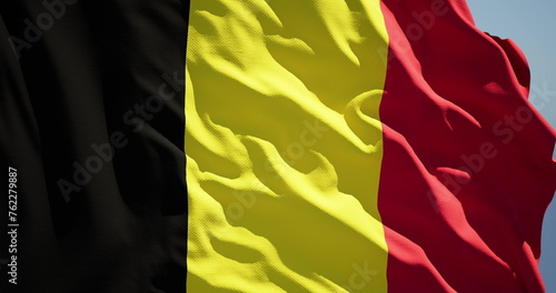 Fotografie Close-up of the national flag of the kingdom of belgium flutters in the wind on