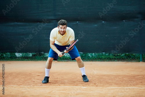 Tennis player waits for serve at back line. © Pavel Losevsky