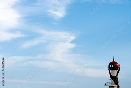 View of the lighthouse with the white clouds on the sea photo