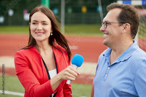 Young female journalist interviews man, focus on woman. photo