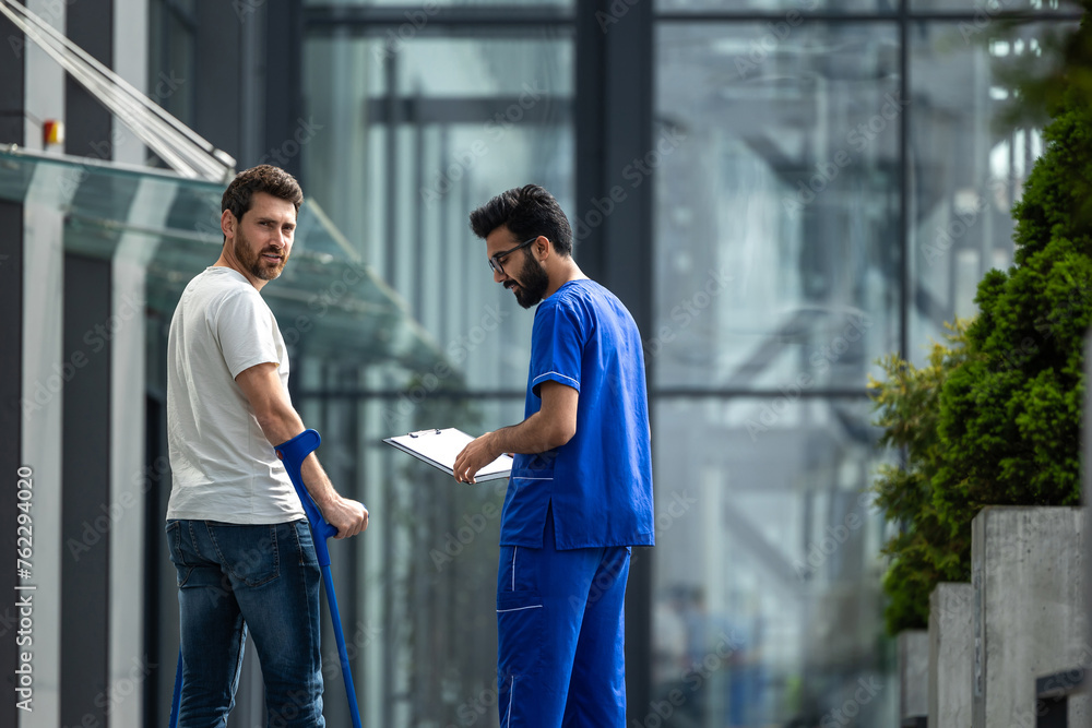 Brunette male nurse and his patient having a walk together Brunette male nurse and his patient having a walk together