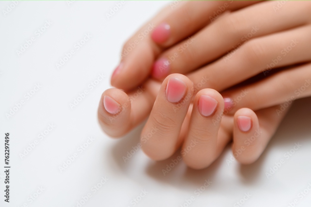 Hands of a beautiful woman on a white background. Delicate hands with natural manicure, clean skin. Light pink nails.