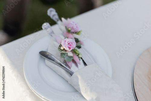 Elegantly arranged tableware with floral accents for a wedding reception. Perfect for catering, event planning