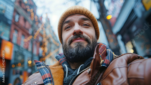 A smiling bearded man in urban setting