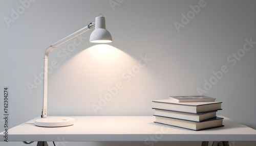 On a white table there is a desk lamp with books lamps well lit © itnozirmia