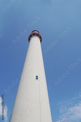 Towering White Lighthouse against Blue Sky 