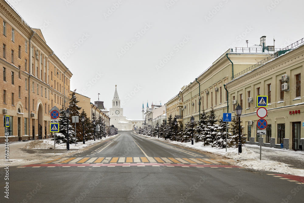 Kremlyovskaya street and Spasskaya tower on winter day. Spasskaya Tower of Kazan Kremlin is its main thoroughfare tower and architectural monument of 16th century.