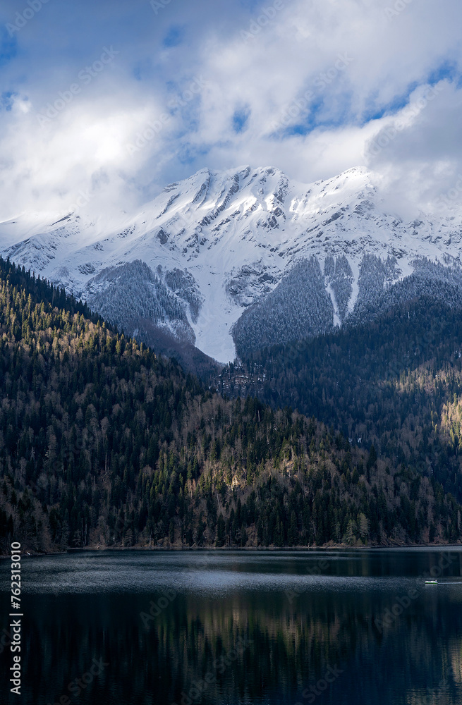 A mountain range with snow on the peaks and a lake in the valley