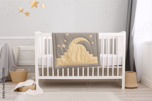 Baby crib with a quilted blanket with a moon and stars, and two baskets with toys.